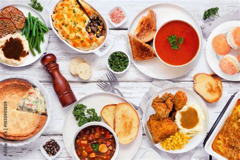 Cozy comfort food table scene. Top down view over a white wood ...